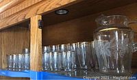Shelved display of clear iced tea and juice glasses with smooth rims and no etching.