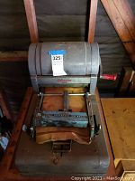 Top view showing the Liberator 100 Speed Printer B, with its gray metal body and visible red handle lever, showing wear and scratches.