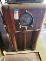 Front view of full wooden console cabinet showing round dial and knobs