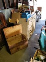 Wood cabinet and large wooden box shown side by side in a cluttered setting.