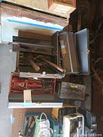 Overview of four metal tool boxes partially opened, displaying various hand tools and accessories inside.