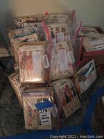 Multiple plastic bags containing stacks of vintage sewing pattern envelopes from Simplicity, McCall's and others.