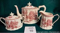 Full set of Florence by Skye McGhie porcelain tea set including teapot, creamer, and sugar bowl with lids showing detailed red pastoral scenes on white background.