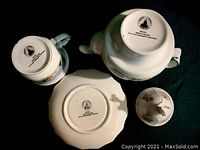 Underside markings of the teapots and cup show Disney copyright and manufacturing details.