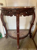 Full view of the semi-circular wooden side table with carved legs and apron, showing overall design and structure.