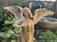 Close-up of angel’s upper body and dove perched on arm