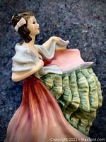Close-up side view of the Royal Doulton porcelain figurine showing the detailed painted dress and shawl.