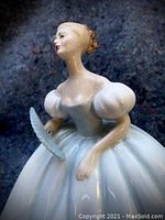 Close-up of the figurine showcasing the upper body, puffed sleeves, and detailed fan held in the hand.