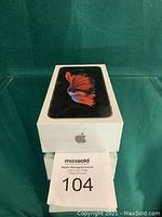 Sealed-looking Apple iPhone 6S Plus retail box on green background.