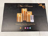 Box for the Nice Dream Flameless Real Wax Candles Set showing three different sized candles and a remote control, indicating flickering flame effect and multiple color options.