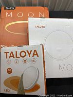 Three boxes of Taloya Moon ceiling lights stacked, showing brand and partial product details.