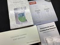 Four boxed and unpacked automatic foaming soap dispensers; includes retail packaging boxes and one dispenser unit shown outside the box.