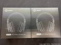 Two unopened boxes of Cowin E7 Pro ANC wireless headphones shown from front with branding and model.