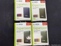 Photo of four KESU external hard drives boxes, three 160GB and one 320GB, showing front packaging with product image and storage size.
