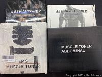 Photo of EMS Muscle Toner and ABS Muscle Toner packaging and user manuals