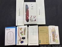 Several wireless mouse boxes and two stylus pen boxes arranged side by side, showing packaging and branding details.
