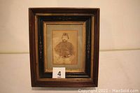 Frontal photo of the framed Civil War soldier photograph with visible tags and frame details