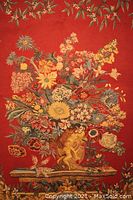 Close-up of the central floral bouquet with cherub figure on a red background.