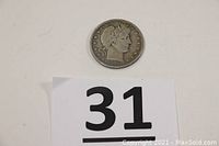 Full view of the coin placed with a number card beneath it.