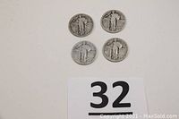 Four Standing Liberty quarters laid out heads side up showing dates 1925, 1926, 1928D, 1930