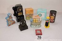 Wide shot showing all nine coin banks in the lot arranged on white surface.