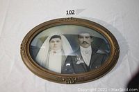 Front view of the oval framed wedding photograph showing the couple and the frame details