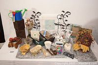 Full view of garden lot items including figurine, boxes, vases, gloves, and framed print