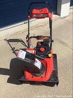 Front view showing housing, chute, and handle assembly