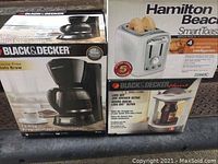 Photo shows three boxed appliances: Black & Decker coffee maker, Hamilton Beach toaster, and Black & Decker jar lid opener.