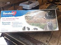 Front packaging showing Havahart brand and raccoon trap information with images of raccoons and the cage trap.