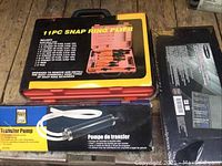 Overview of Snap Ring Plier Set and Transfer Pump boxed items on floor
