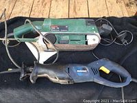 Bosch PBS 75 belt sander and Mastercraft reciprocating saw placed side by side with cords visible.