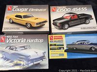 Four AMT model car kits displayed together showing box art and condition.