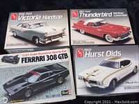 Four model car kits arranged showing box tops with car images and branding.