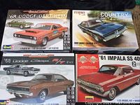 Top-down photo showing four model boxes: 68 Dodge Dart HEMI, 69 Dodge Charger R/T, 68 Dodge Charger R/T, and 61 Impala SS 409.