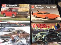 Four vintage model car kit boxes, including '71 Duster 340, 1969 Dodge Charger Daytona, Revell '68 Dodge Charger R/T, and Dick Tracy model kit.