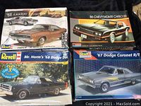 Four boxed plastic model kits stacked together: '68 Dodge Dart, '86 Chevy Monte Carlo SS, Mr. Norm's '68 Dodge Dart, and '67 Dodge Coronet R/T