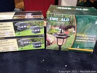 Photo showing boxes of two Fusion solar fence post light sets and one Emerald solar powered garden lights set.