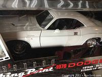 Front side view of white 1970 Dodge Challenger die cast model inside box with scale and branding visible