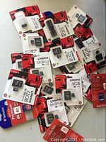 Overhead view of multiple sealed memory cards and flash drives scattered on floor