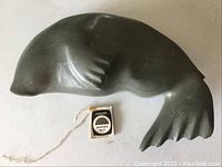Seal stone carving with a Canada Eskimo Art tag attached.