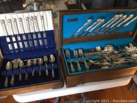 Wide shot of two wooden flatware cases on a table, showing both sets and wood exteriors