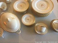 Top-down view of entire china set showing stacks of plates, cups and tureen