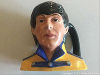 Front view of figural jug showing Paul McCartney’s facial features and jacket