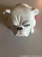 Front view showing detailed bulldog face and ears, glazed ceramic finish.