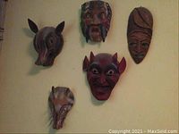 Group shot of all five masks arranged on wall
