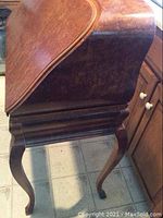 Side profile showing serpentine drop-front and cabriole legs