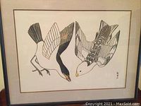Full view of framed bird artwork showing two birds in flight with black and white wings and yellow beaks.