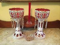 Front view of both candle holders, hanging lamp and small bowl on marble surface