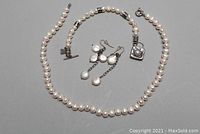 Photo showing the full set of fresh water pearl necklace, earrings, and silver bracelet with pearl charm.